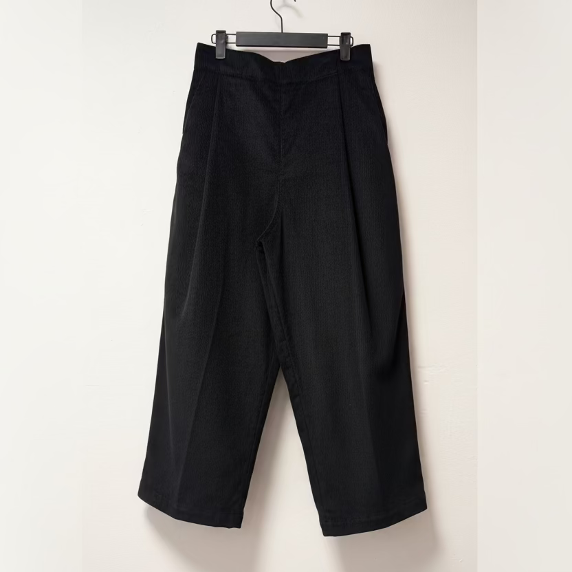 Black pants hanging on a white wall