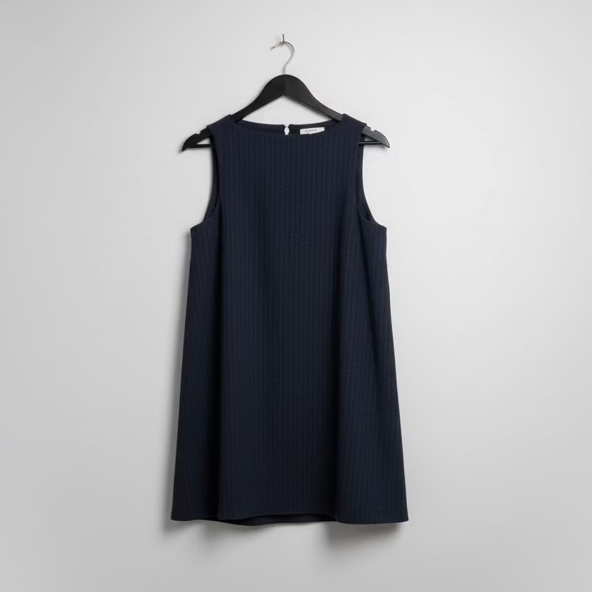 Navy blue sleeveless top on a hanger against a white wall