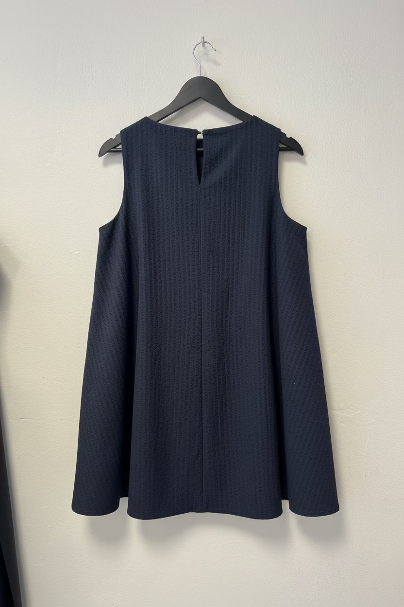 Dark blue sleeveless top on a hanger against a white background