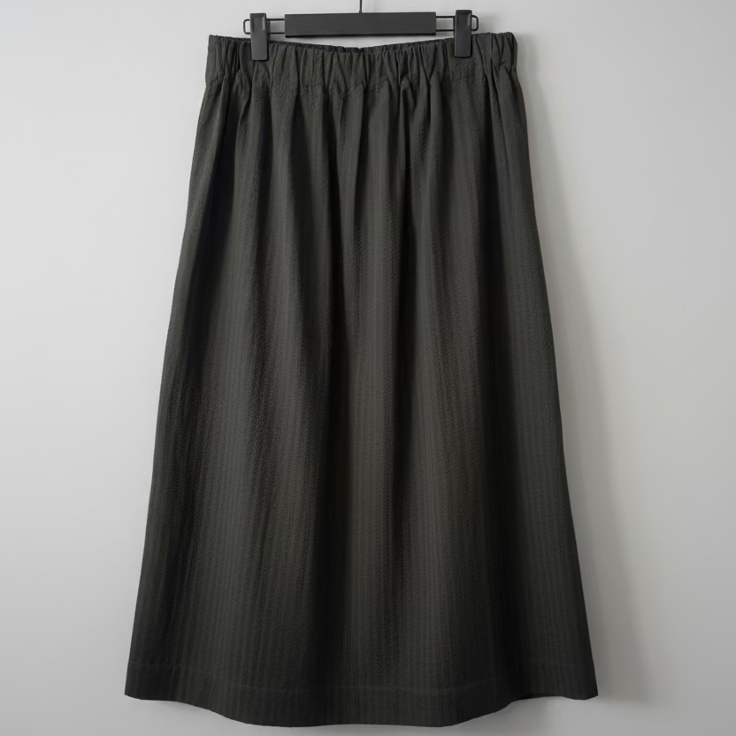 Black skirt on a hanger against a plain background