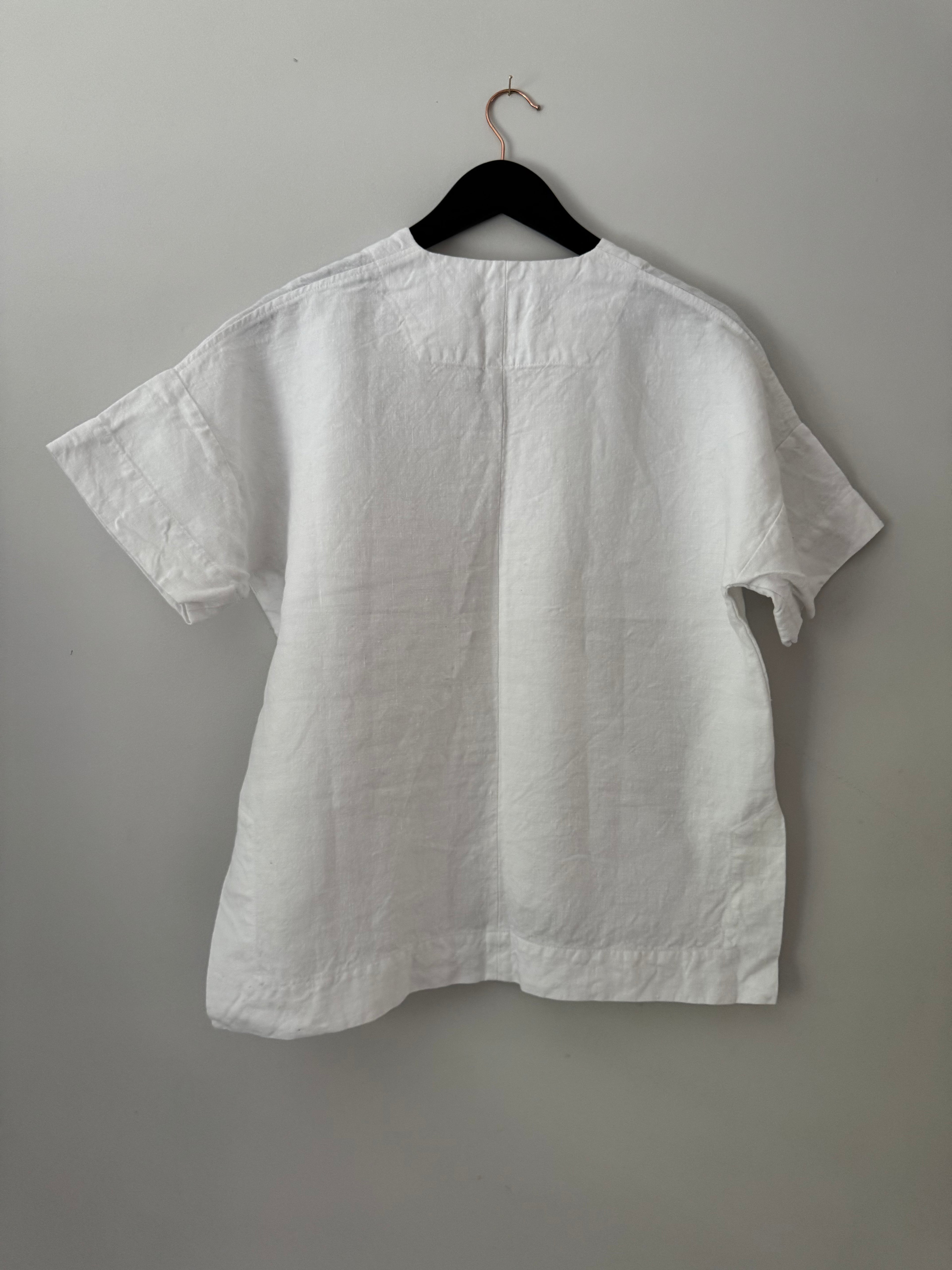 White shirt on a hanger against a gray background