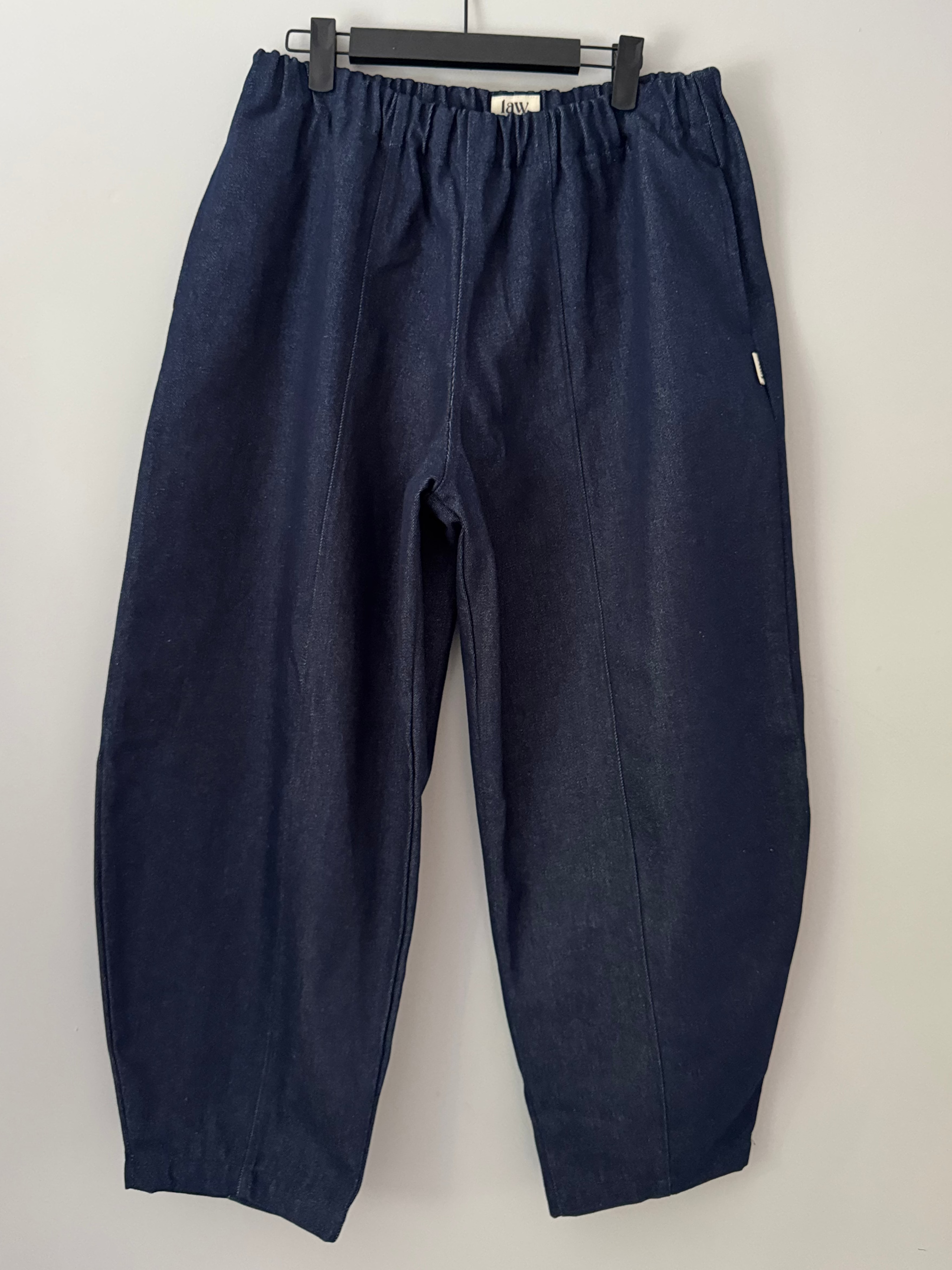 Navy blue pants on a hanger against a white background