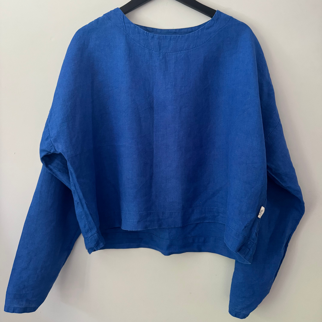 Blue sweater on a hanger against a white background