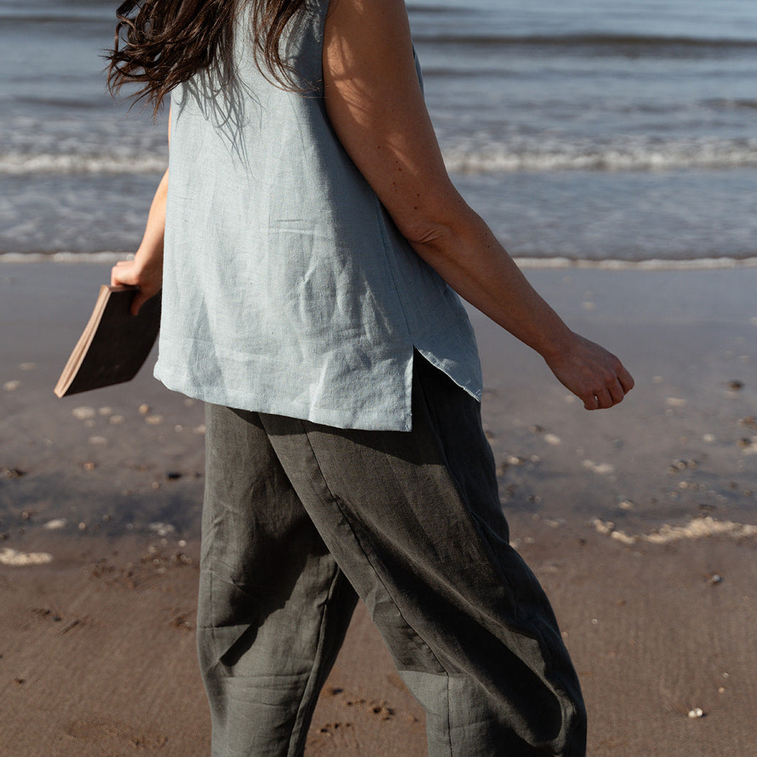 girl on beach with blue linen top and trousers