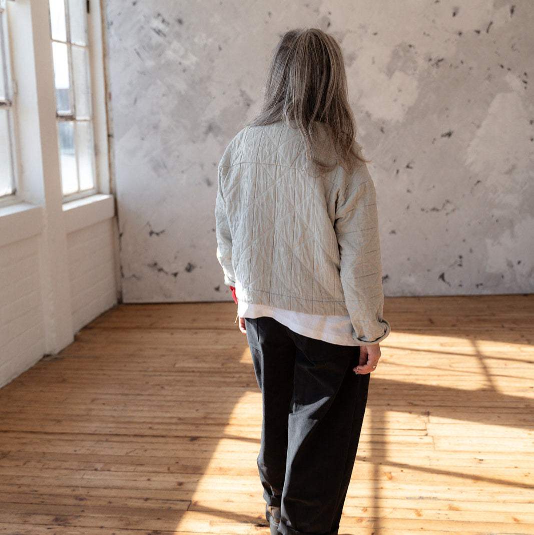 LAW Design studio Person standing in a sunlit room with wooden floor and white walls.