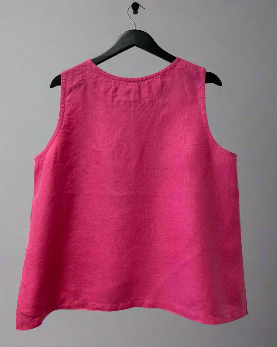 Pink tank top on a hanger against a white wall